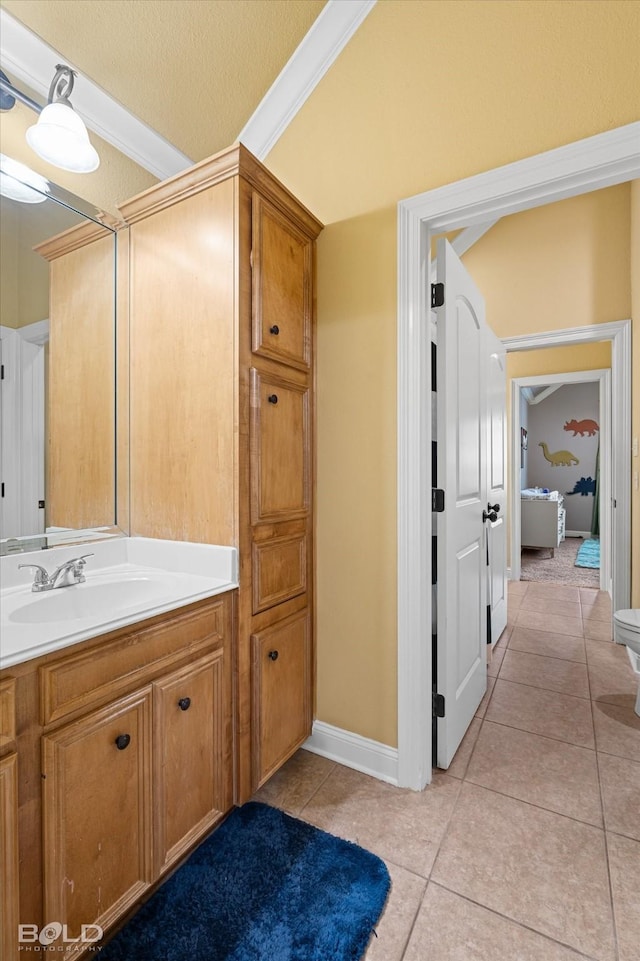 bathroom with vanity, tile patterned floors, ornamental molding, and toilet