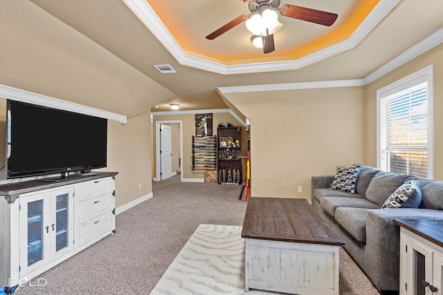 living room featuring crown molding, a raised ceiling, ceiling fan, and carpet