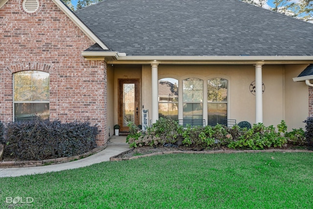 view of exterior entry featuring a lawn