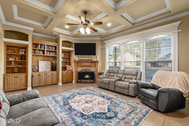 tiled living room featuring coffered ceiling, ornamental molding, built in features, and ceiling fan