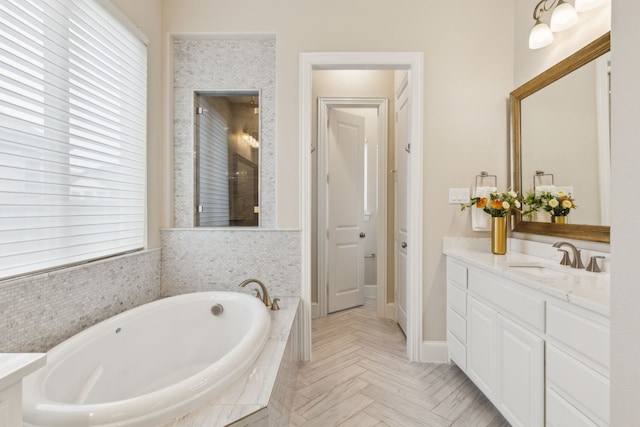 bathroom featuring vanity, parquet floors, and a relaxing tiled tub