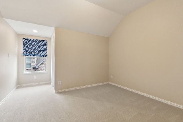 additional living space featuring lofted ceiling and light colored carpet