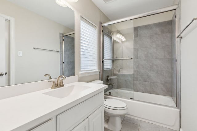 full bathroom featuring tile patterned flooring, enclosed tub / shower combo, vanity, and toilet