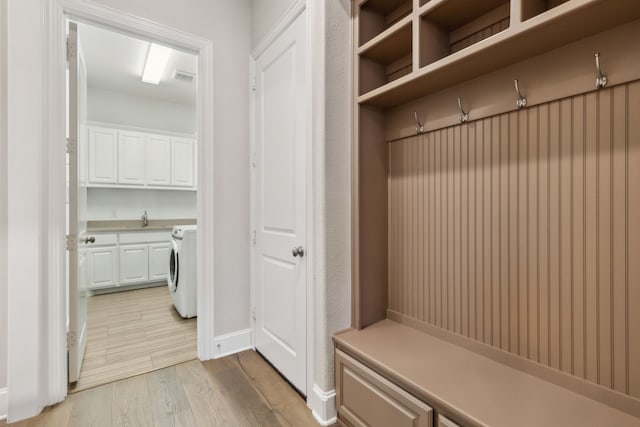 mudroom featuring washer / clothes dryer, light hardwood / wood-style floors, and sink