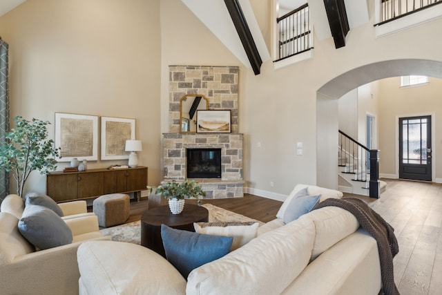 living room featuring hardwood / wood-style floors, a fireplace, and high vaulted ceiling