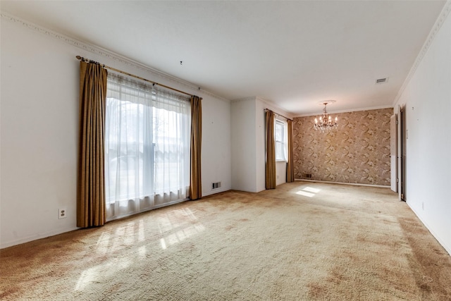 empty room with crown molding, carpet floors, and a notable chandelier