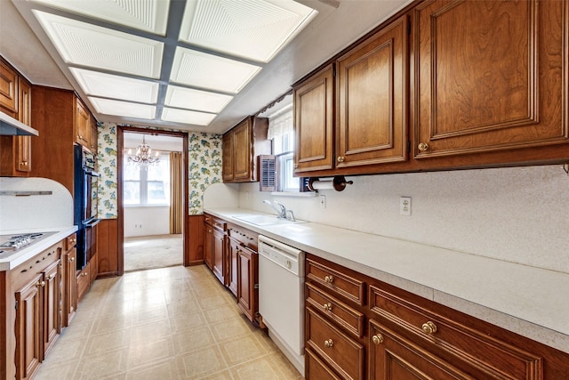 kitchen featuring sink, dishwasher, an inviting chandelier, hanging light fixtures, and stainless steel gas stovetop