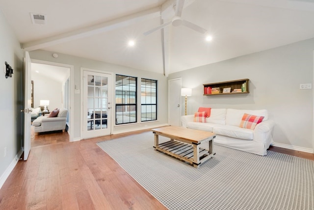 living room featuring ceiling fan, light hardwood / wood-style floors, and vaulted ceiling with beams