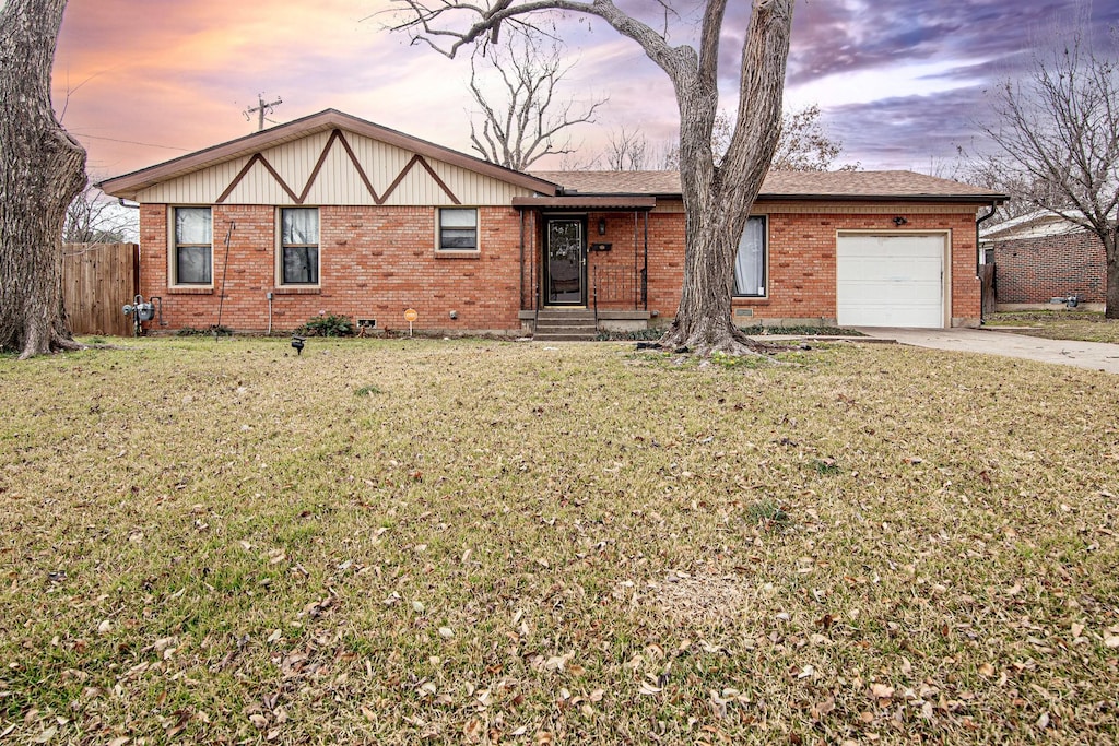 view of front of home with a garage and a lawn