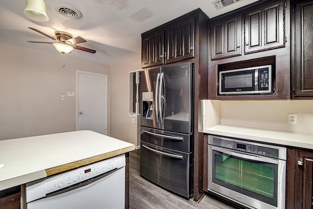 kitchen featuring ceiling fan, dark brown cabinetry, stainless steel appliances, and light wood-type flooring