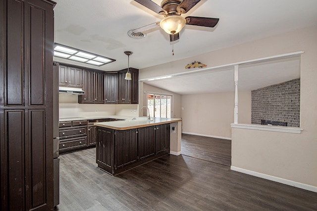 kitchen with hanging light fixtures, sink, dark brown cabinets, and hardwood / wood-style floors