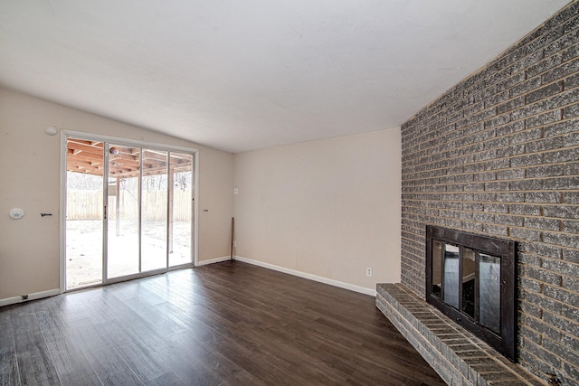 unfurnished living room featuring dark wood-type flooring, a fireplace, and vaulted ceiling