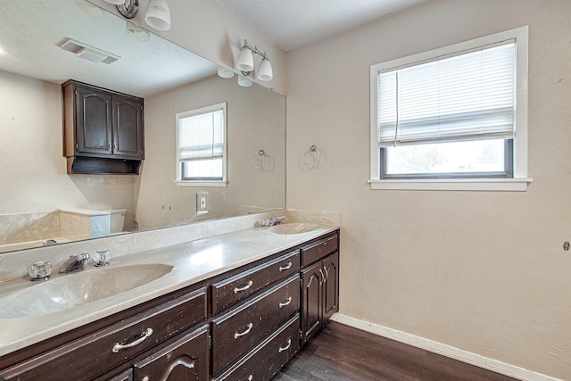 bathroom featuring hardwood / wood-style flooring, vanity, toilet, and a textured ceiling