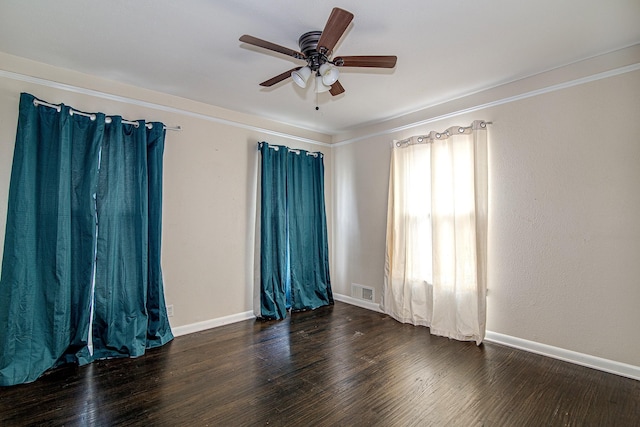 empty room with dark wood-type flooring and ceiling fan