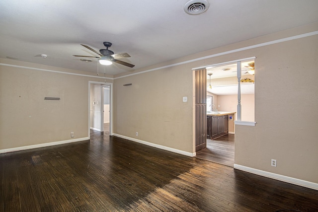 empty room featuring dark wood-type flooring, ceiling fan, and sink