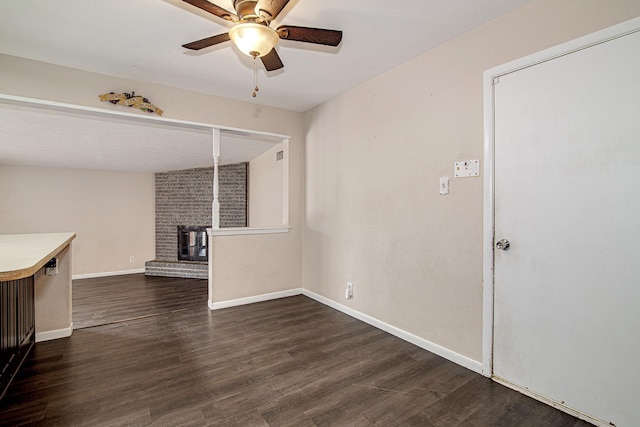 unfurnished living room with dark hardwood / wood-style flooring and ceiling fan