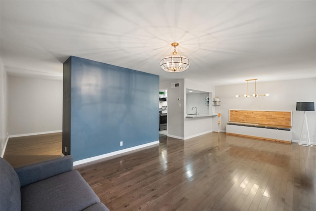 living room with dark hardwood / wood-style flooring, sink, and a notable chandelier