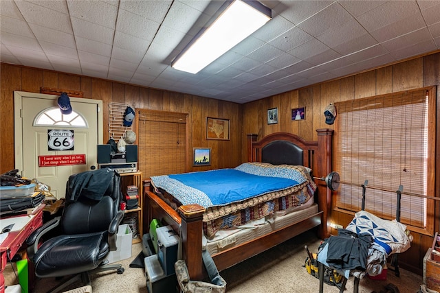 carpeted bedroom with wooden walls