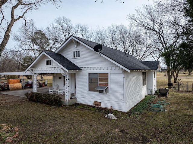 bungalow-style home with a porch, central AC unit, and a front yard