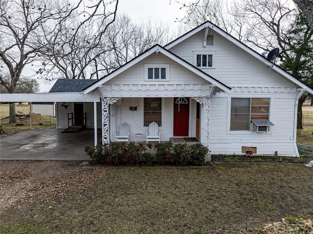 bungalow-style house with cooling unit, a front yard, a carport, and covered porch