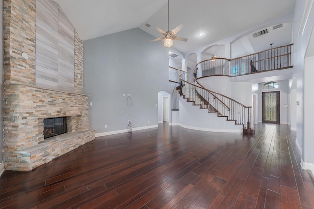 unfurnished living room featuring dark hardwood / wood-style flooring, a fireplace, high vaulted ceiling, and ceiling fan