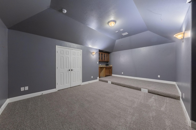 bonus room featuring lofted ceiling and carpet flooring