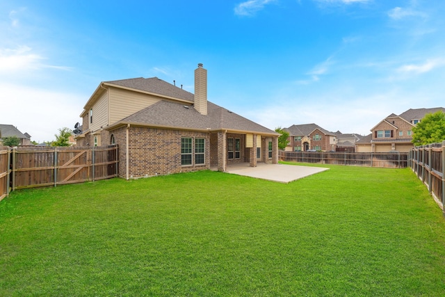 rear view of property with a yard and a patio area