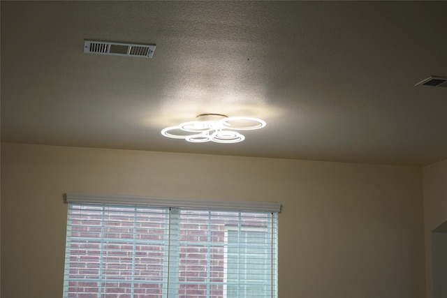 details featuring visible vents and a textured ceiling