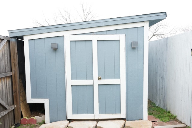 view of shed featuring fence