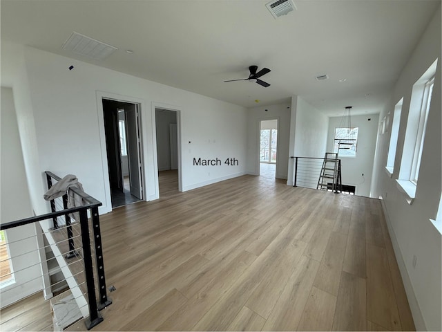 unfurnished living room featuring visible vents, baseboards, and light wood-style floors