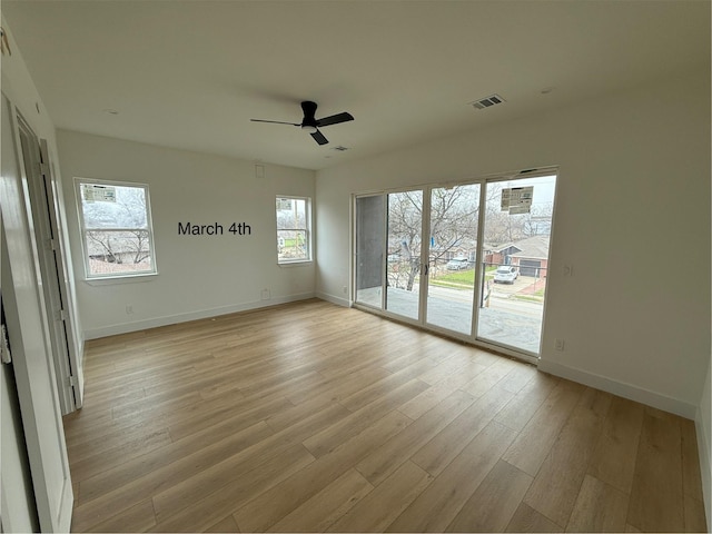 empty room featuring visible vents, baseboards, light wood-style floors, and a ceiling fan