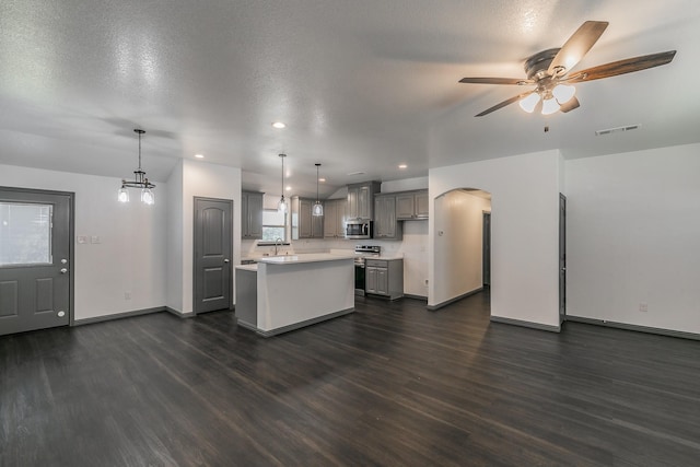 kitchen featuring a kitchen island, visible vents, light countertops, appliances with stainless steel finishes, and gray cabinets