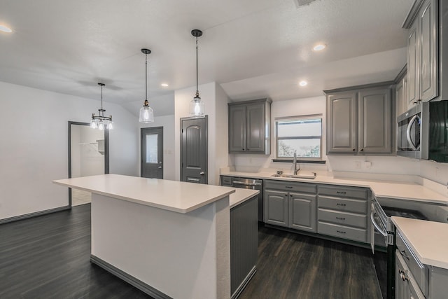 kitchen with a center island, light countertops, gray cabinetry, appliances with stainless steel finishes, and a sink