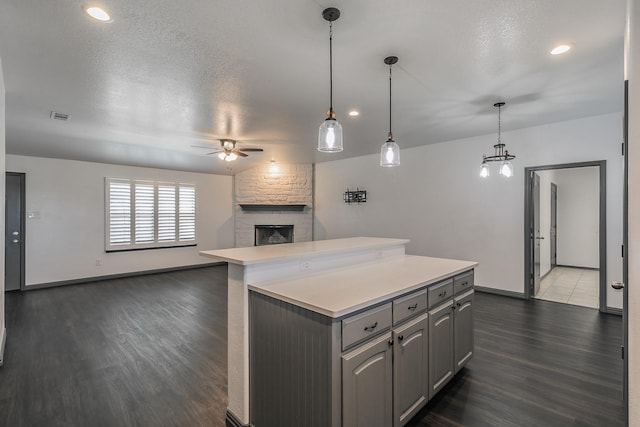 kitchen featuring ceiling fan, visible vents, open floor plan, light countertops, and gray cabinets