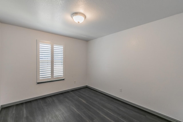 unfurnished room with a textured ceiling and dark wood-style flooring