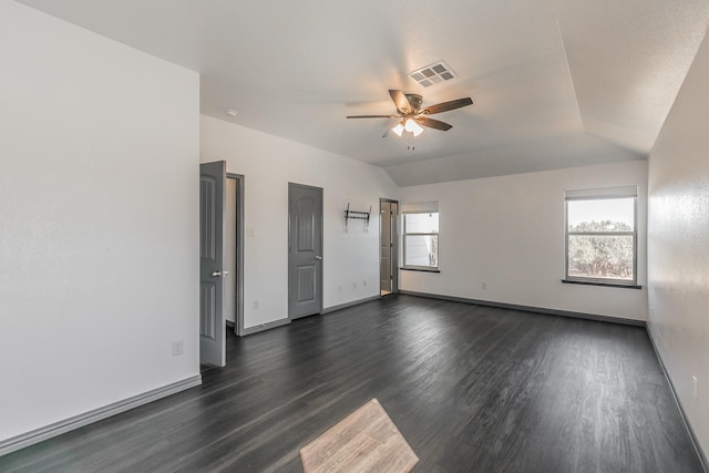 unfurnished room featuring lofted ceiling, ceiling fan, dark wood-type flooring, and visible vents