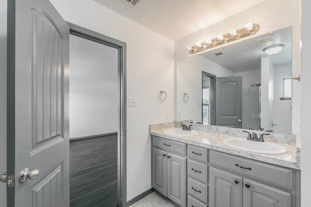 bathroom featuring double vanity, a sink, and visible vents