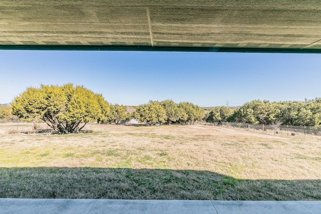 view of yard featuring a rural view and fence