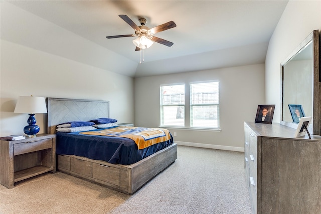 bedroom with vaulted ceiling, light colored carpet, and ceiling fan