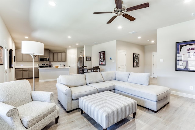 living room featuring ceiling fan and light hardwood / wood-style floors