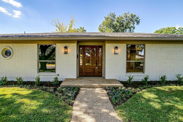 property entrance featuring a lawn