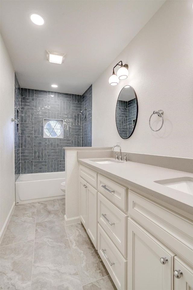 full bathroom featuring vanity, tiled shower / bath, and toilet