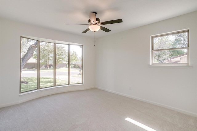 carpeted spare room featuring ceiling fan