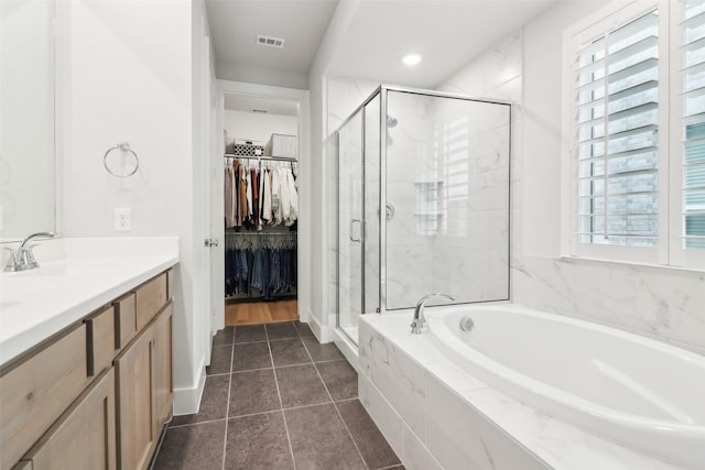 bathroom with independent shower and bath, vanity, and tile patterned flooring