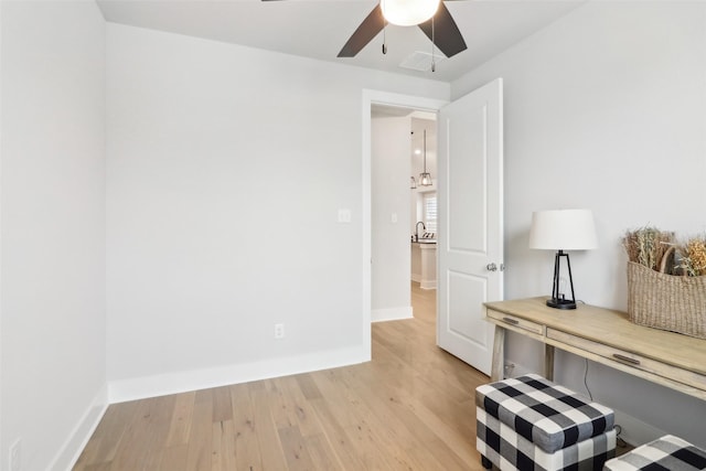 interior space featuring sink, light hardwood / wood-style floors, and ceiling fan