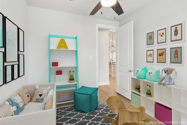 game room featuring hardwood / wood-style flooring, sink, and ceiling fan