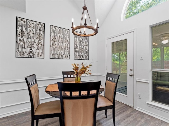 dining area featuring hardwood / wood-style floors, a notable chandelier, and high vaulted ceiling