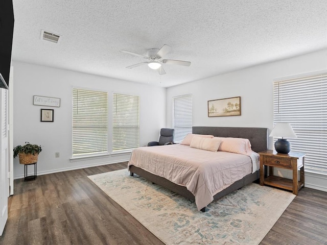 bedroom featuring a textured ceiling, dark wood-type flooring, and ceiling fan