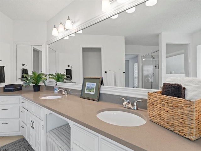 bathroom featuring vanity, a shower with door, and tile patterned flooring