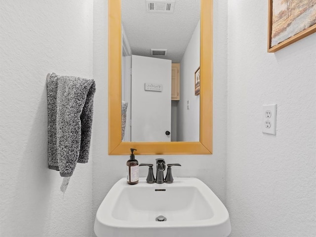 bathroom featuring sink and a textured ceiling